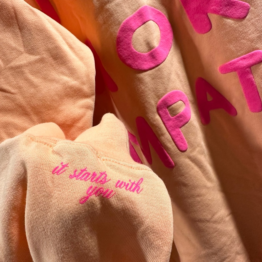 Mayfair Group 'The World Needs More Empathy Peach Fuzz
Crewneck' L/XL